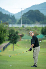 ゴルフを楽しむシニア男性