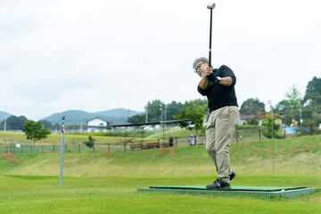 ゴルフを楽しむシニア男性