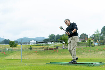 ゴルフを楽しむシニア男性