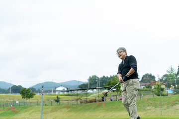 Obraz premium ゴルフを楽しむシニア男性