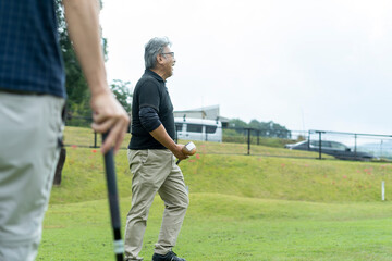 ゴルフを楽しむシニア男性