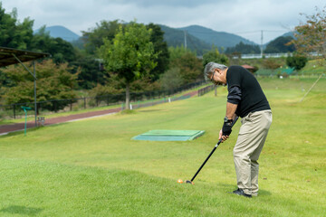 ゴルフを楽しむシニア男性