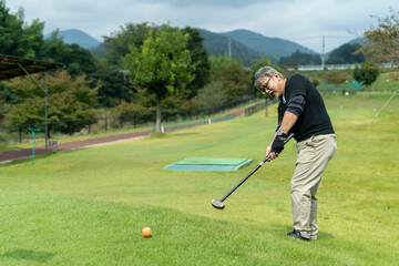 ゴルフを楽しむシニア男性