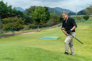 ゴルフを楽しむシニア男性