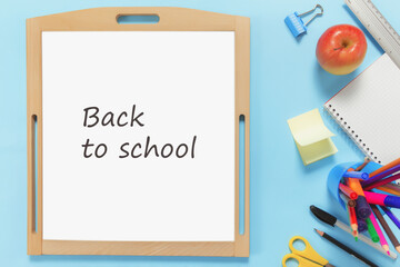 Flat lay with school concept on blue background with accessories, white board