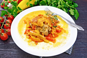 Chicken with pepper in white plate on black board