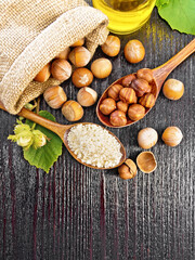 Flour and hazelnuts in two spoons on dark board top