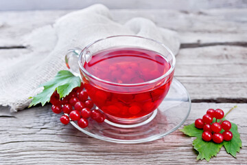 Tea from viburnum in cup with berries on gray board