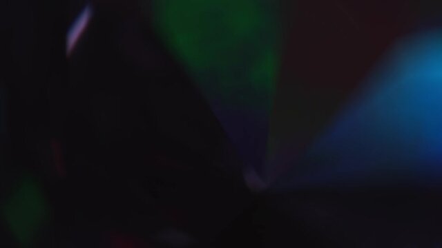 Rainbow neon multicolored light through crystal glass prism. Abstract background