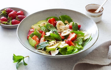 Ripe strawberries, apples, bananas, coconut and mixed salad leaves  healthy salad