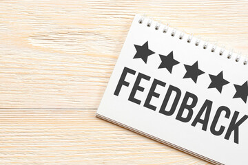 5 stars feedback, customer experience concept, notepad on white aged wooden table