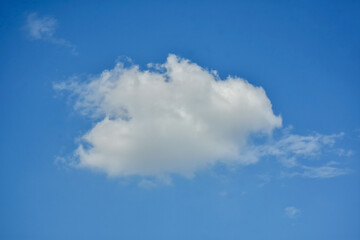 Beautiful cumulus clouds against the blue daytime sky.