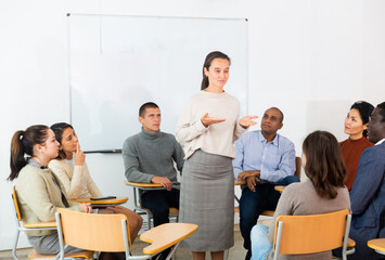 Business woman addressing multicultural office staff meeting