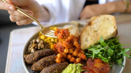 Vegan interpretation of classic English breakfast. Beans, falafels, vegetables and avocado