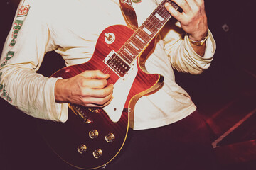 Close up of guitarist musician playing guitar on stage.