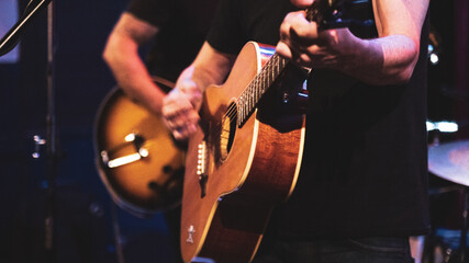 Close up of guitarist musician playing guitar on stage. - obrazy, fototapety, plakaty