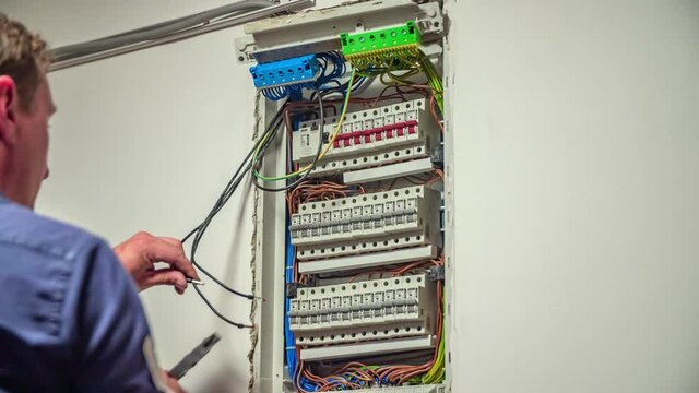 Male Electrician testing electrical power of solar panels on residential.Industrial electrician testing voltage on the solar power plant.