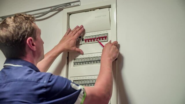 Close up of professional Electrician closing control box inside house, after test and installation