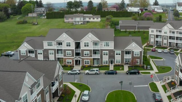 Aerial of large modern apartment building complex. Residential housing in USA. Establishing pullback reveal reverse dolly shot.