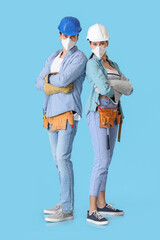 Happy couple with repair tools on color background