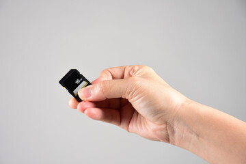 Hand holding SD card isolate on white background