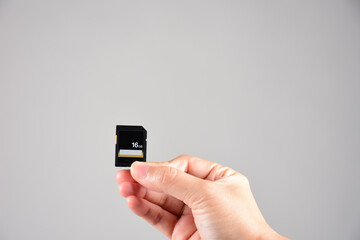Hand holding SD card isolate on white background
