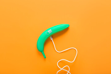 Creative composition with painted banana and USB cable on color background