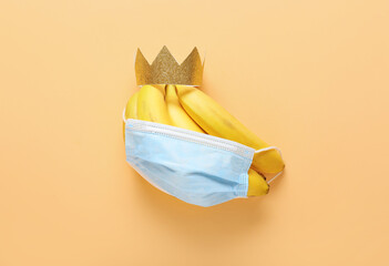 Creative composition with bananas, medical mask and crown on color background