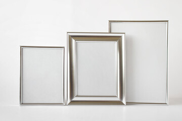 Mockup template with set of three silver glossy metallic frames with blank space on white...