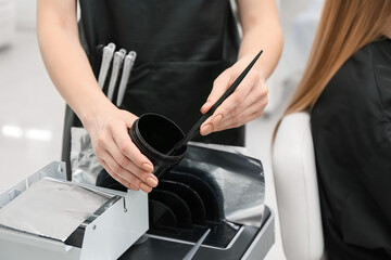 Female hairdresser working in beauty salon, closeup