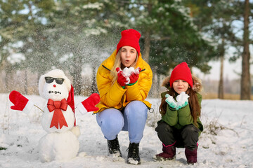 Happy family with snowman in park