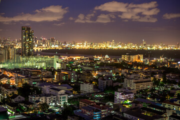 Obraz premium The high angle background of the city view with the secret light of the evening, blurring of night lights, showing the distribution of condominiums, dense homes in the capital community