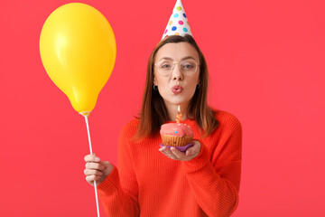 Beautiful woman celebrating birthday on color background