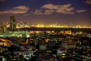 Obraz premium The high angle background of the city view with the secret light of the evening, blurring of night lights, showing the distribution of condominiums, dense homes in the capital community