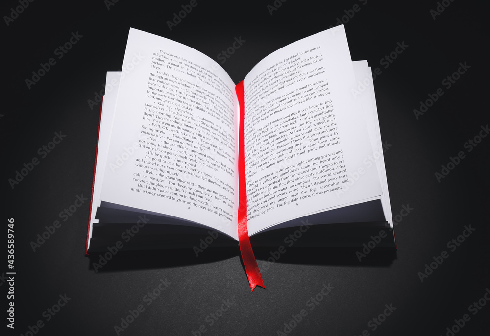 Wall mural Open book with bookmark on dark background