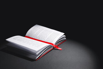 Open book with bookmark on dark background