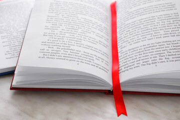 Open book with bookmark on light background, closeup