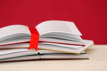 Open books with bookmark on color background, closeup