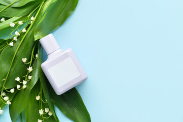 Bottle of perfume and lily-of-the-valley flowers on color background, closeup