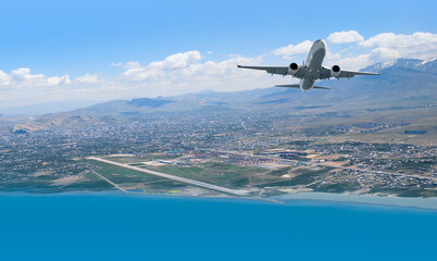 Fototapeta na wymiar Airplane taking off from airport - Passenger airplane is flying over amazing mountains and sea - Travel by air transport
