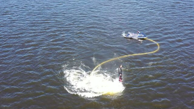 Man on the flyboard. Flyboard view from drone. Aerial view of water extreme action sport. Guy is flying at the aquatic flyboard