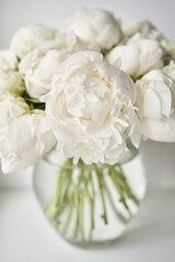 Obraz na płótnie Canvas White peonies in a glass vase. Beautiful peony flower for catalog or online store. Floral shop concept . Beautiful fresh cut bouquet. Flowers delivery