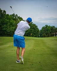 Unidentifiable male golfer hitting on a fairway