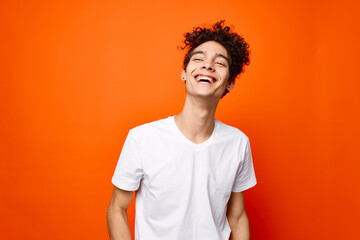 guy in a white t-shirt gesturing with his hand on an orange background