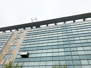 man cleaning windows of a high-rise building. Window washer at work. workers on a suspended...