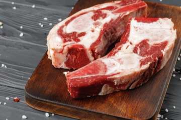 Uncooked raw beef brisket on wooden board