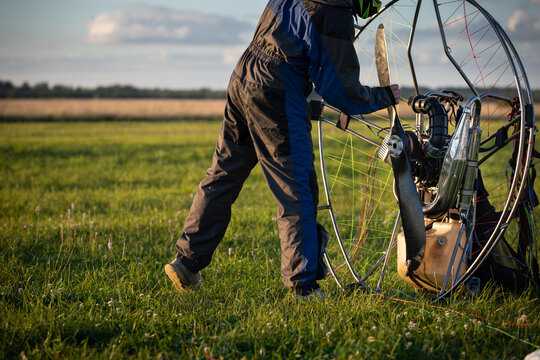 The pilot is preparing a paralet with a gasoline engine for flights. The man starts the engine. Paragliding for individual paragliding flights. Wing flight preparation. Extreme sports.
