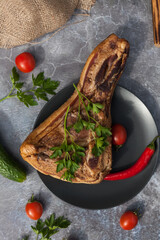 A piece of fresh steak, bacon, meat with vegetables, tomatoes and peppers. A piece of smoked meat close up. 