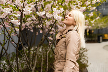 Pretty woman in cherry blossom garden, spring time