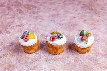 Homemade cupcakes with whipped cream and berries on top.